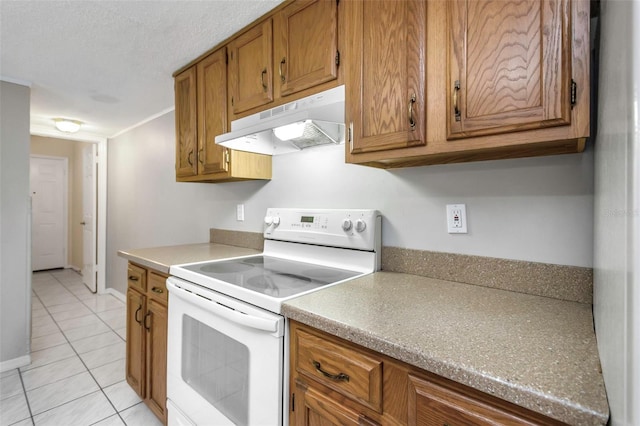 kitchen with white electric range oven, light tile patterned floors, brown cabinets, and under cabinet range hood