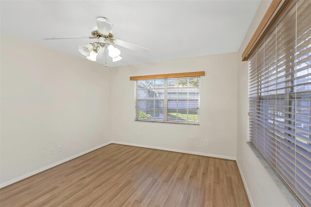 spare room featuring ceiling fan, baseboards, and wood finished floors