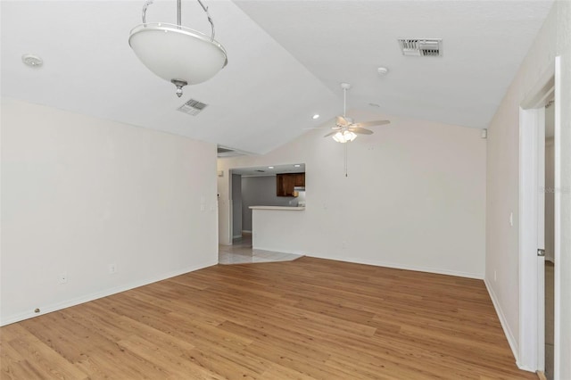 unfurnished living room with ceiling fan, lofted ceiling, visible vents, and light wood-type flooring