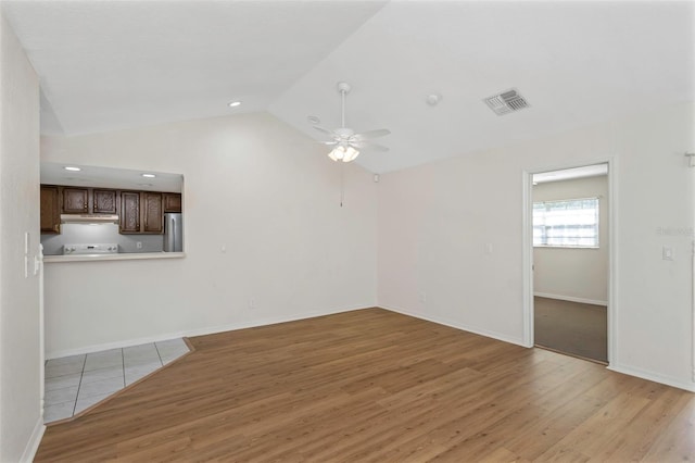 unfurnished living room with light wood finished floors, visible vents, lofted ceiling, and a ceiling fan