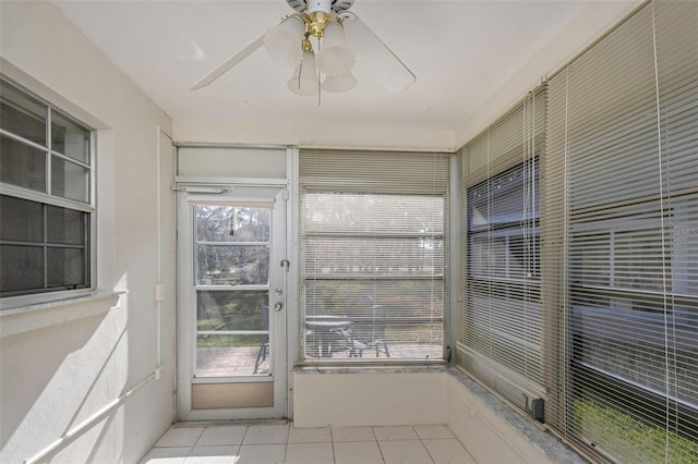 unfurnished sunroom featuring a healthy amount of sunlight and a ceiling fan