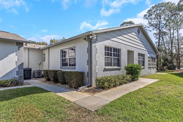 view of side of property with a lawn and stucco siding