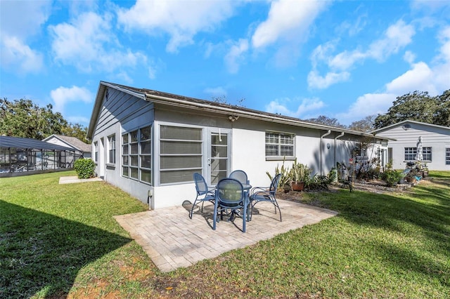 back of house featuring a patio area, stucco siding, and a yard