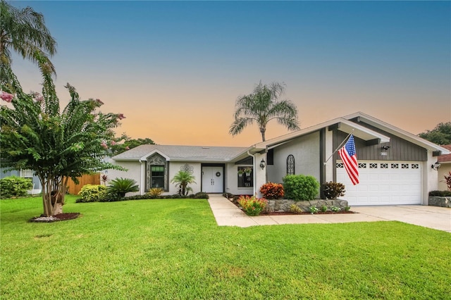 view of front of home featuring a garage, stucco siding, driveway, and a lawn