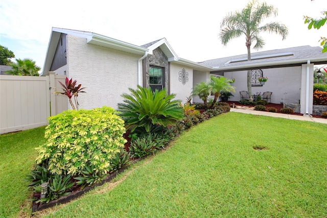 view of front of property featuring stucco siding, fence, and a front yard