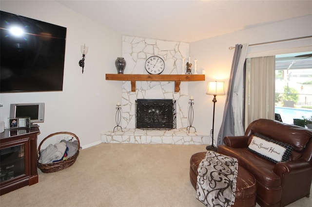 living room with a stone fireplace and carpet flooring