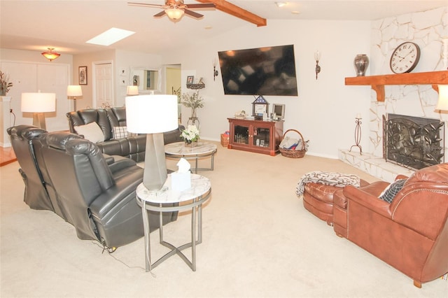 living room featuring baseboards, a ceiling fan, lofted ceiling with skylight, carpet floors, and a fireplace