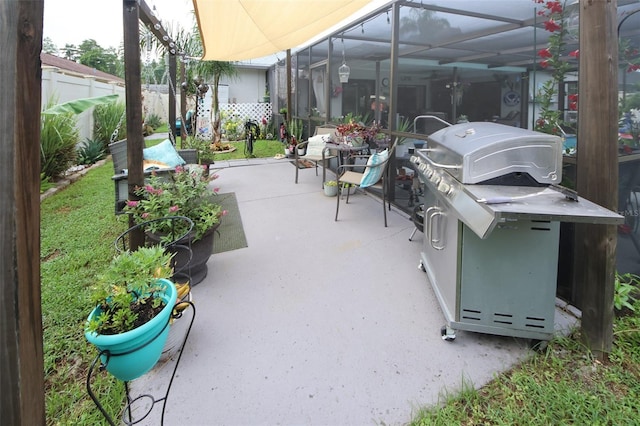 view of patio / terrace featuring a lanai, fence, and grilling area