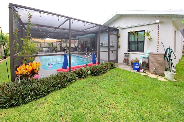 pool featuring glass enclosure and a lawn