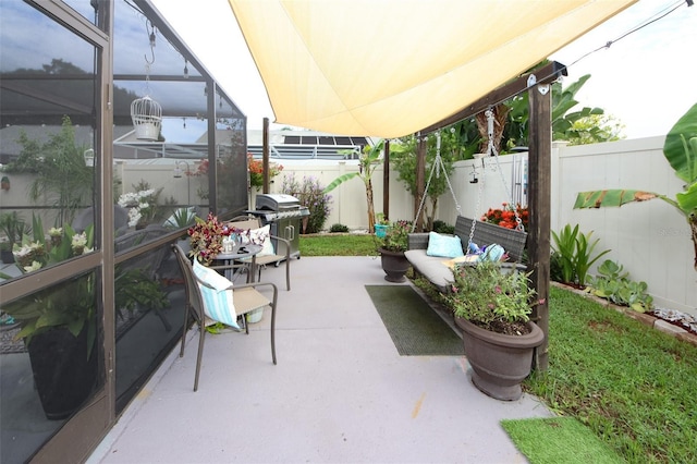 view of patio with a lanai, a fenced backyard, and a grill