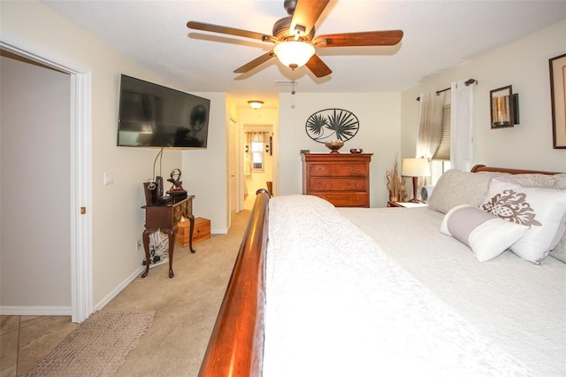 bedroom with ceiling fan, baseboards, connected bathroom, and light colored carpet