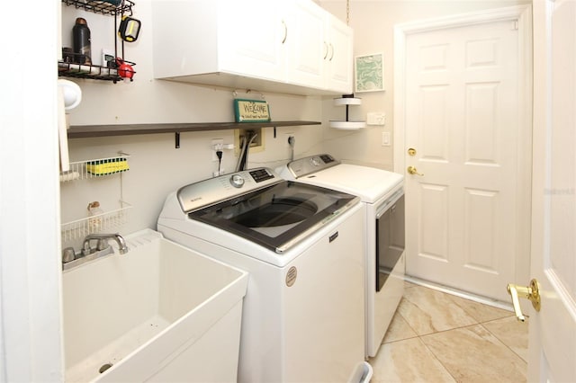 washroom featuring washing machine and clothes dryer, a sink, and cabinet space