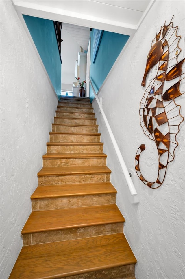 staircase featuring a textured wall