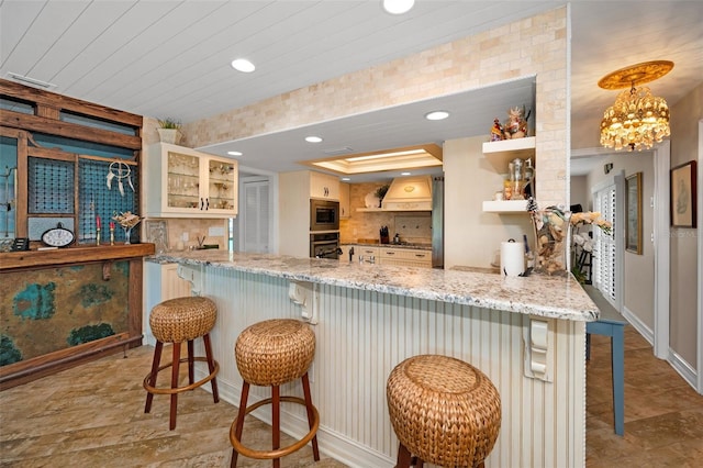 kitchen with recessed lighting, stainless steel appliances, light stone countertops, tasteful backsplash, and glass insert cabinets