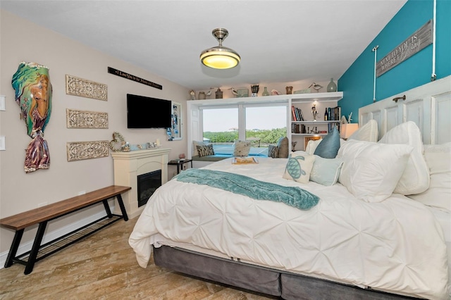 bedroom featuring a glass covered fireplace