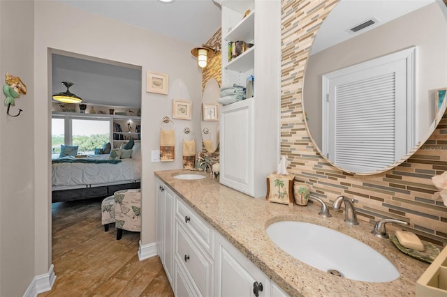 bathroom with ensuite bathroom, backsplash, a sink, and visible vents