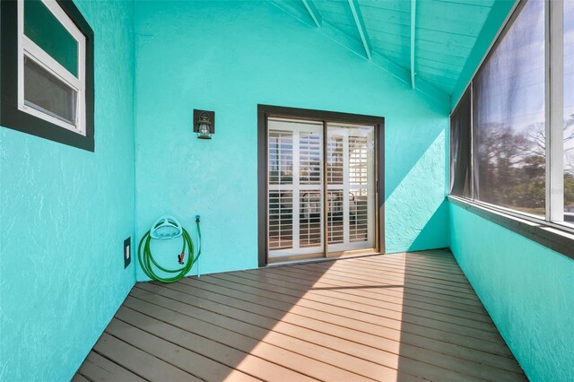 unfurnished sunroom with lofted ceiling with beams, wooden ceiling, and a wealth of natural light