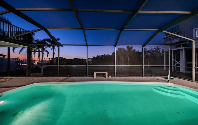 pool at dusk with a lanai, a patio area, and an outdoor pool