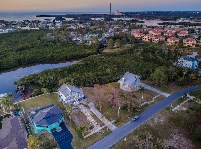 aerial view at dusk featuring a water view