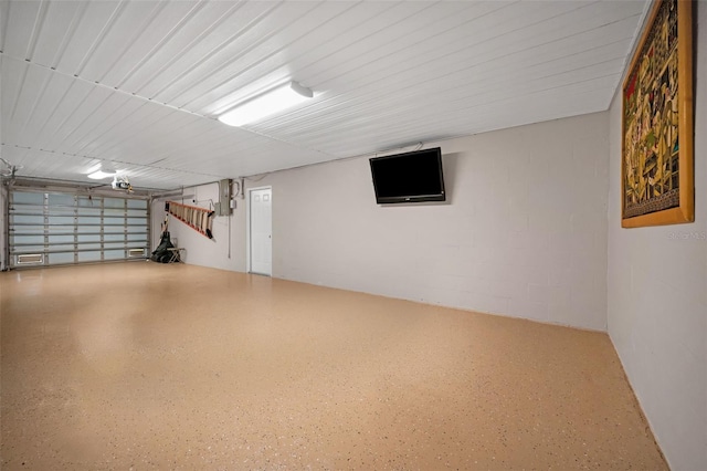 garage with concrete block wall and a garage door opener