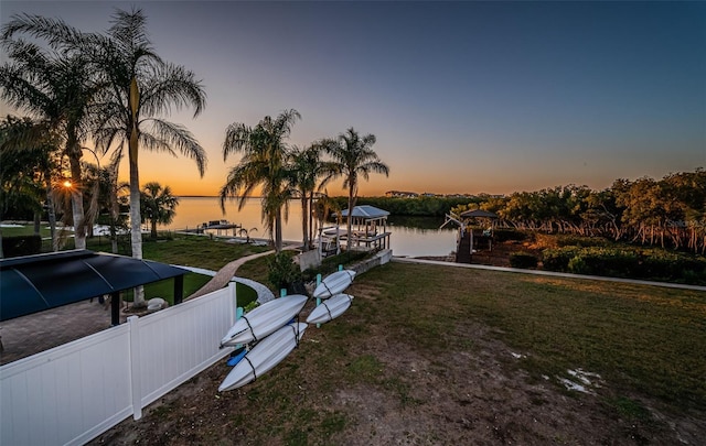 dock area with a yard, a water view, and boat lift