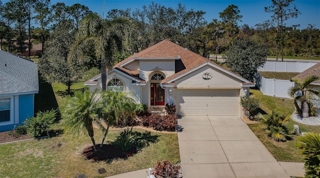 view of front of house featuring fence, a shingled roof, stucco siding, concrete driveway, and a garage