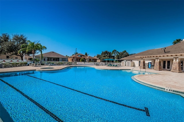 pool featuring a patio, french doors, and fence