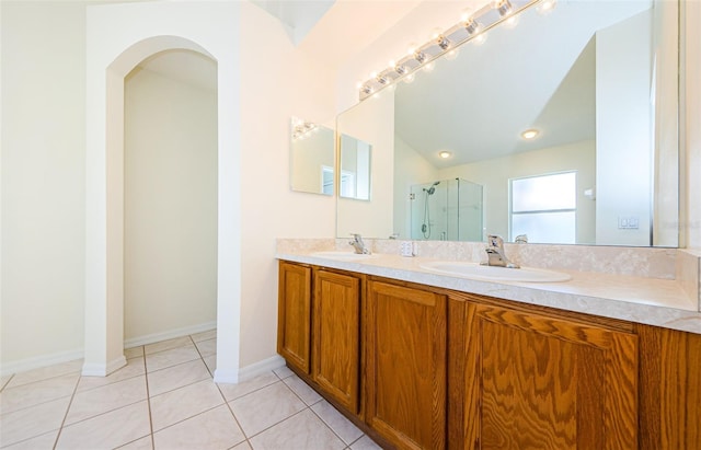 full bathroom featuring a sink, double vanity, a shower stall, and tile patterned flooring