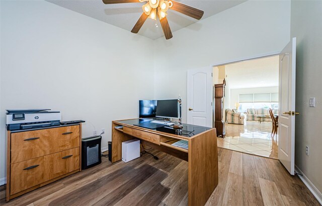 office area featuring baseboards, light wood-style flooring, and a ceiling fan