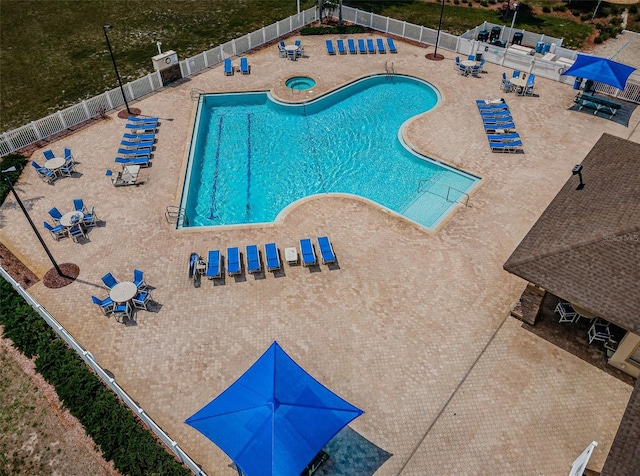 community pool with a patio and fence