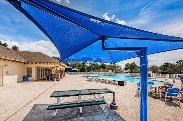 community pool featuring a patio area and fence