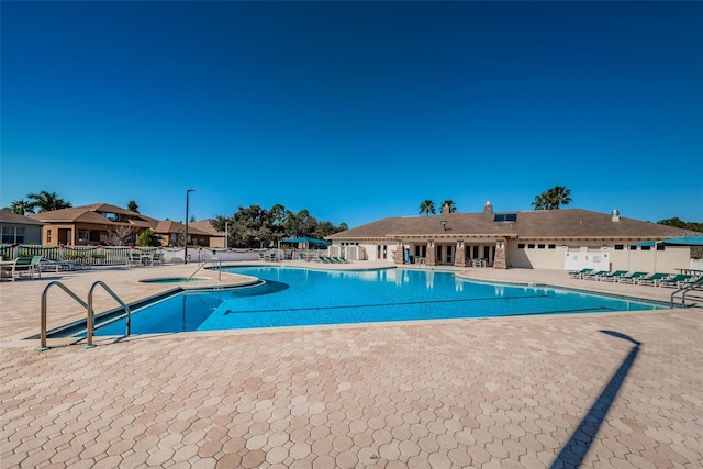 community pool featuring a patio and fence