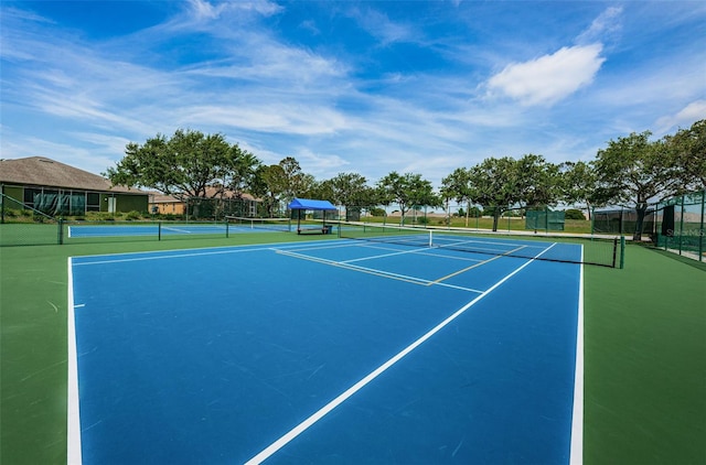 view of tennis court featuring fence