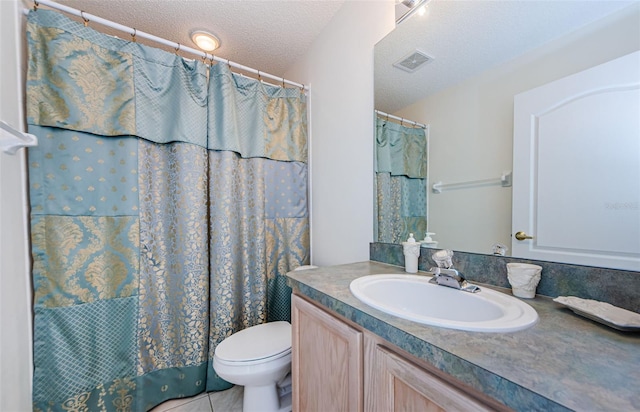 bathroom featuring visible vents, toilet, vanity, tile patterned floors, and a textured ceiling