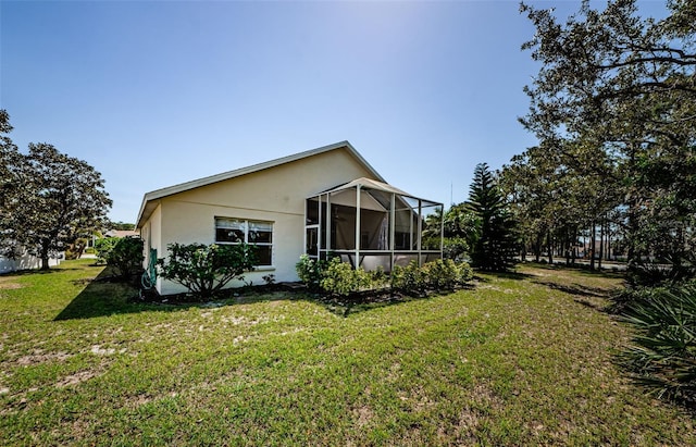 view of property exterior with stucco siding, a lawn, and a sunroom