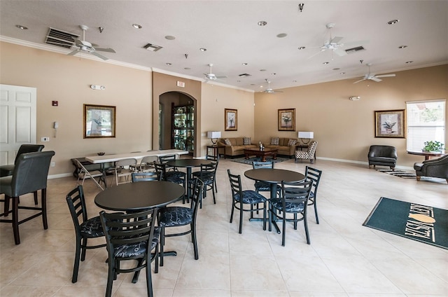 dining area featuring ornamental molding, visible vents, arched walkways, and ceiling fan