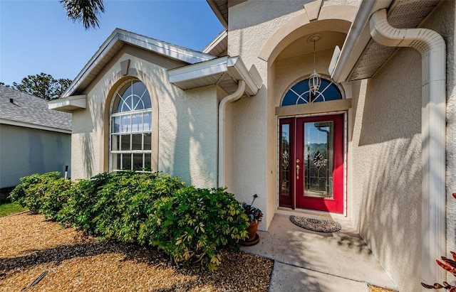 doorway to property featuring stucco siding