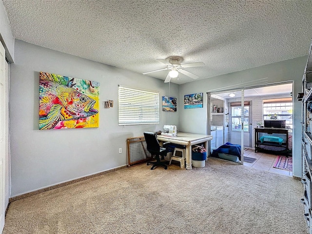 carpeted home office featuring a textured ceiling, ceiling fan, independent washer and dryer, and baseboards