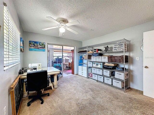 office area with a textured ceiling, carpet, and a ceiling fan