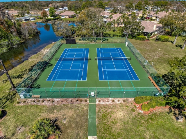 view of sport court with a water view and fence