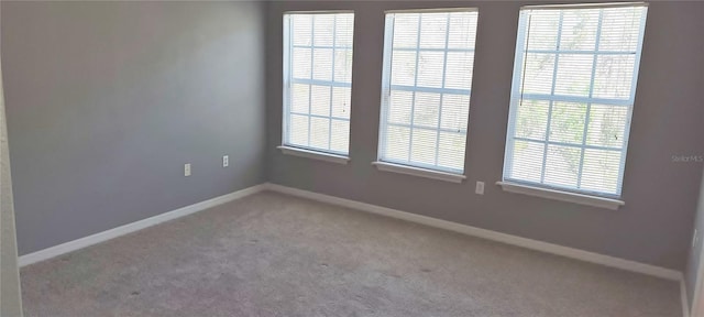 spare room with carpet and baseboards