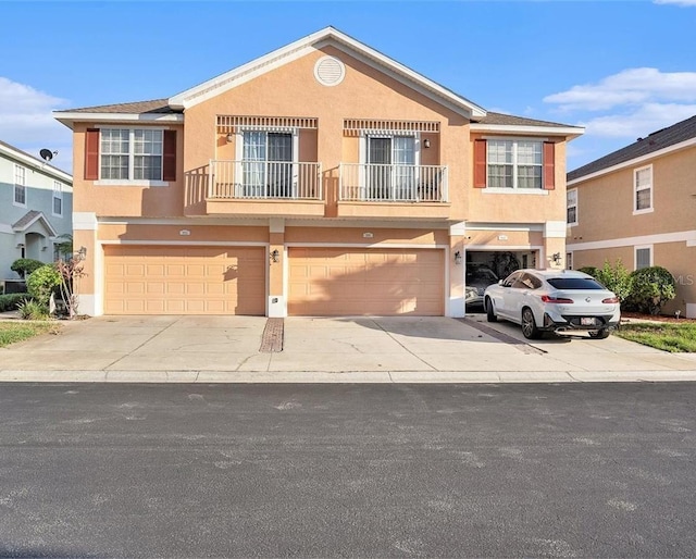 view of front of home featuring an attached garage, concrete driveway, and stucco siding