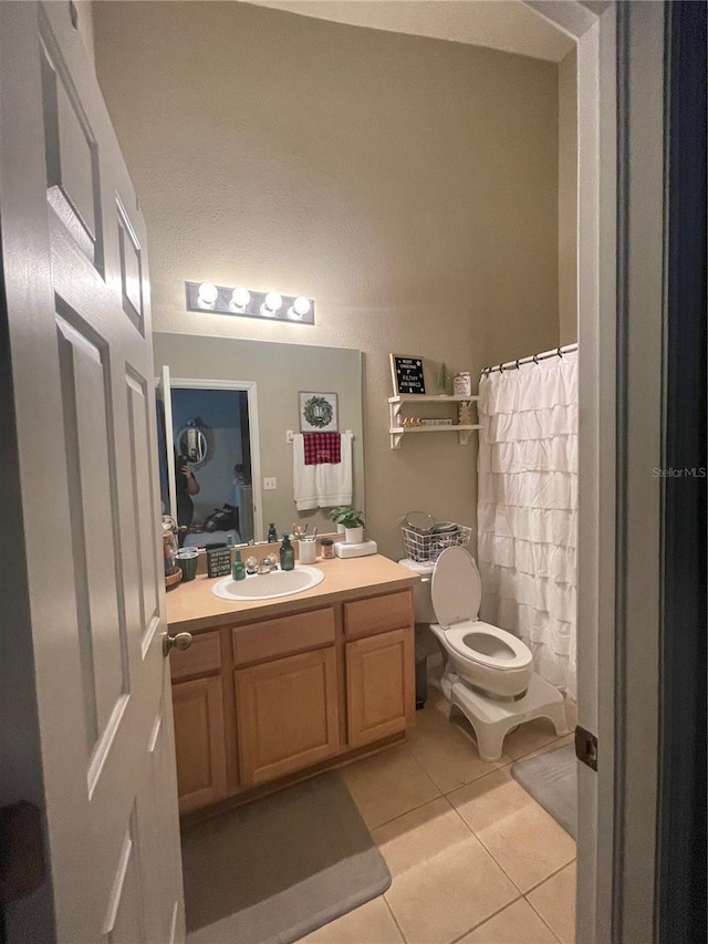 bathroom featuring a shower with shower curtain, vanity, toilet, and tile patterned floors