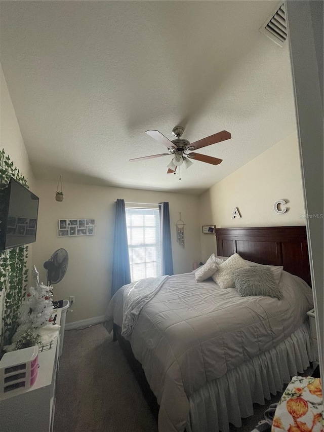 carpeted bedroom with a textured ceiling, ceiling fan, visible vents, and baseboards