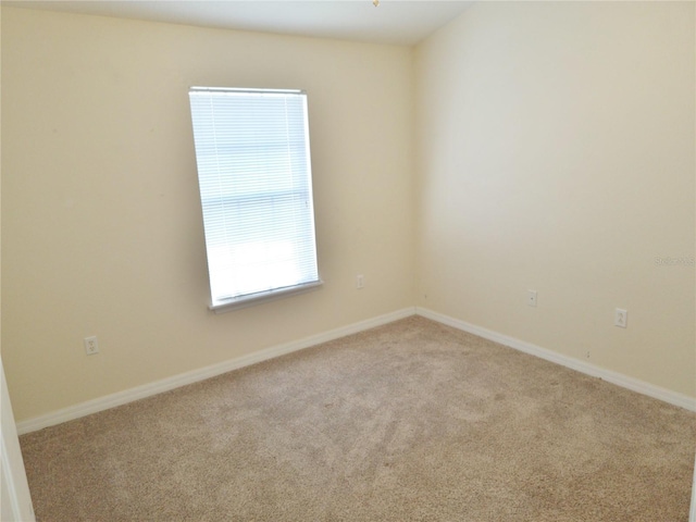 empty room with baseboards and light colored carpet