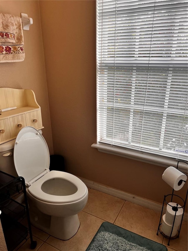 bathroom featuring tile patterned flooring, a wealth of natural light, and baseboards