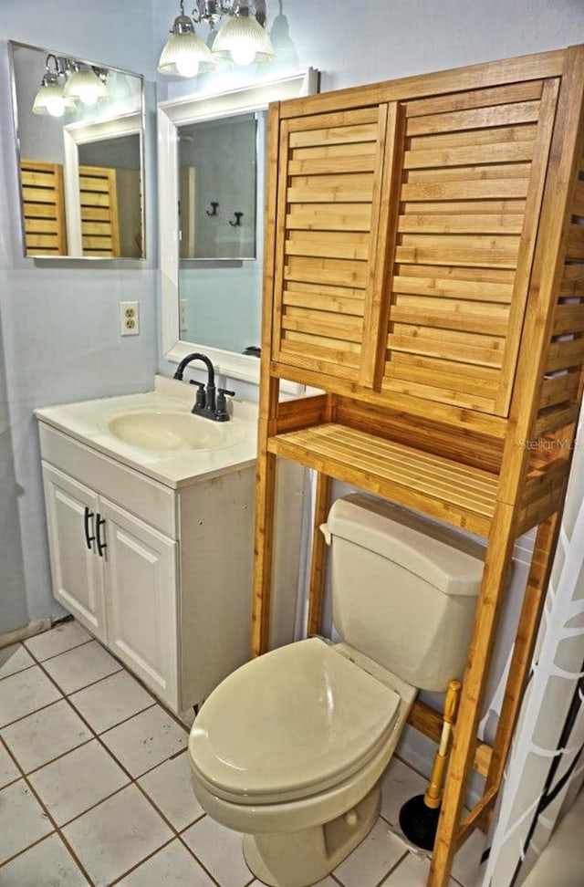 half bathroom featuring tile patterned floors, toilet, and vanity