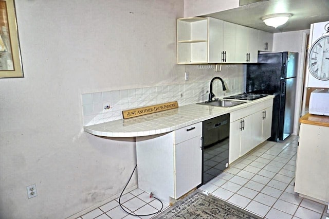 kitchen featuring black appliances, tasteful backsplash, light tile patterned floors, and white cabinets