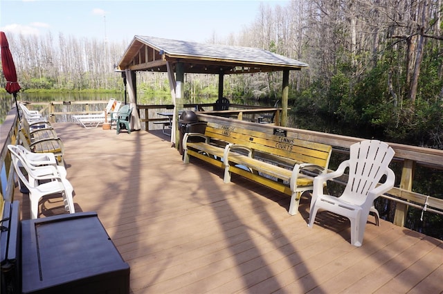 wooden deck featuring a gazebo and a view of trees