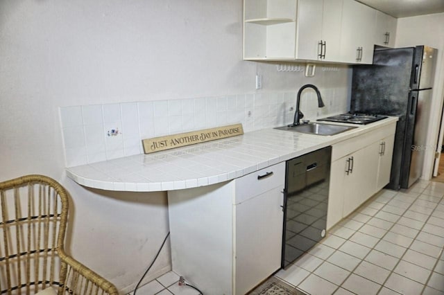 kitchen featuring open shelves, a sink, black dishwasher, white cabinetry, and tasteful backsplash